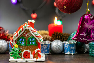 Colorful Christmas baubles, a toy house and garlands sparkle. Design for any greeting or party invitation.