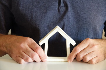 maison blanche sur le bureau entre les mains