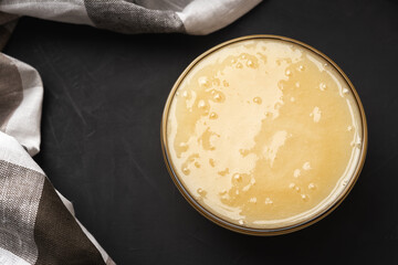 Thick light cream honey with a glass bowl near the napkin close-up, top view
