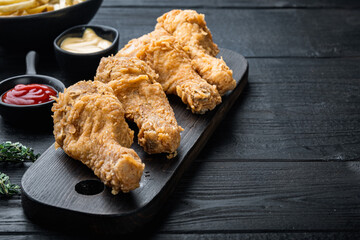 Chicken leg breaded on black wooden table, with copy space
