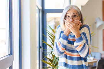 middle age woman covering mouth with hands with a shocked, surprised expression, keeping a secret...