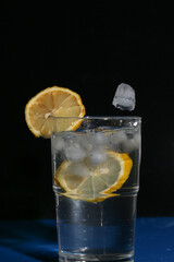 Zitronenplatsch in Glas mit Eiswürfel.