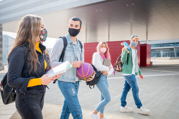 Multiracial students with face mask walking speaking wearing protective mask during pandemic codvid19 at college campus - New normal lifestyle with social distance in coronavirus time