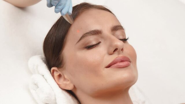 pretty woman face and erbium laser working on it