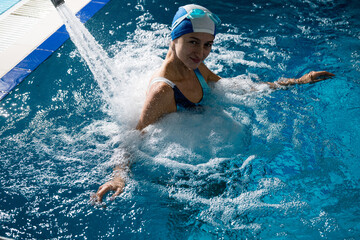 Woman doing hydromassage in the sports pool