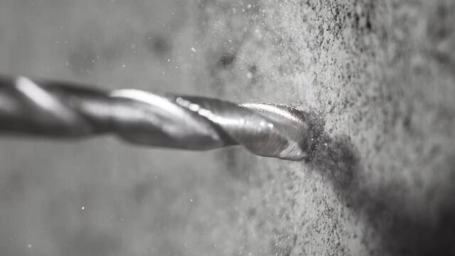 Super slow motion of detail of a drill bit drilling into concrete. Filmed on very high speed cinema camera, 1000 fps.