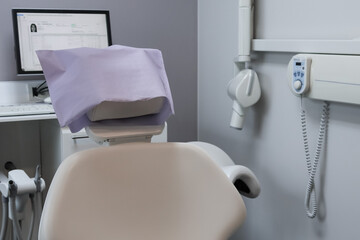 dental chair in hospital.

Dental chair in a hospital with a computer in the background, close-up side view.