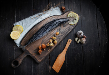 Fresh raw mackerel on the kitchen board. Old textured wooden table. Top view.