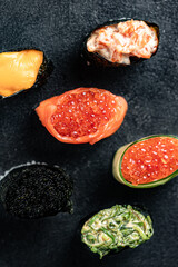 Sushi Rolls Set, maki, philadelphia and california rolls, on a Black background.