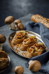Still life picture of delicious and healthy bruschetta or sandwich with roasted garlic and champignon mushrooms on the blue, textured table