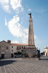 Obraz premium Old town centre with the obelisk devoted to patron Saint Cono and the church of San Francesco, Teggiano, Salerno, Italy. UNESCO heritage site in the Diano National Park.