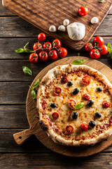 Homemade pizza with tomatoes mozzarella cheese olives and basil - top pof view