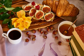 Coffee and croissant for Breakfast. French toast with figs near a yellow rose. High quality photo