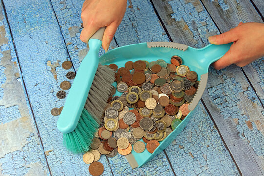 Sweeping Up British Coins In To A Dust Pan. Disposable Income Concept.