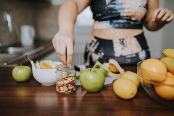 Young overweight woman slicing fresh fruit and preparing healthy meal in home kitchen.