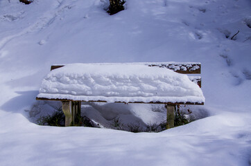 Bench with thick layer of snow. High quality photo