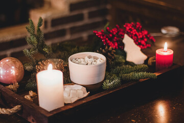 Christmas hot chocolate with mini marshmellows in an old ceramic mug with candles on a wooden background