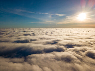 Fototapeta na wymiar Aerial high flight over curly clouds. The sun's rays shine on the clouds.