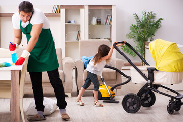 Young male contractor cleaning the house with his small daughter