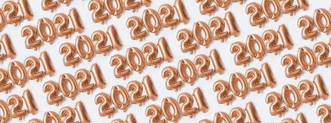 Foil ballons gold party in the form of number 2021. New Year party decoration. Minimal holiday concept. Creative flat lay Christmas background.