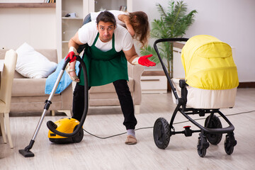 Young male contractor cleaning the house with his small daughter