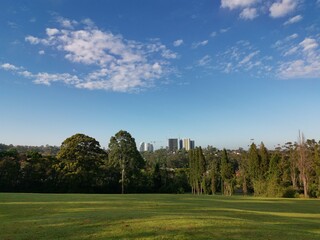 Beautiful view of a park with green grass and tall trees and deep blue sky with light clouds in the background, Heritage park, Castle Hill, Sydney, New South Wales, Australia
