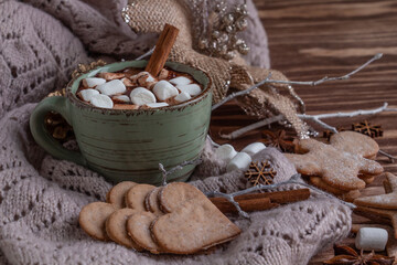 atmospheric Christmas composition, a cup of cocoa with marshmallows, gingerbread cookies, sweets, cinnamon.