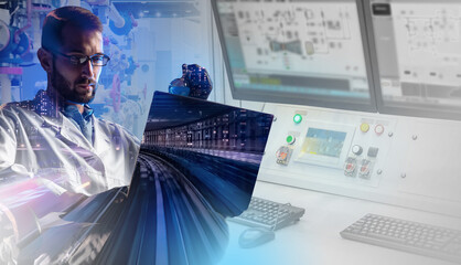 Man runs a railway. Man with a laptop at control room. Translucent railway in foreground. Concept - railway station control room. Modern checkpoint. Work as a dispatcher. Control over railways.