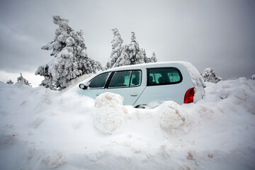 Car stuck in deep snow on mountain road - winter traffic problem
