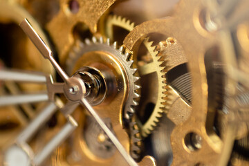Macro photograph of the internal gears of the machine of a bronze and steel wristwatch. Selective focus.