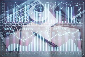 Stock market graph and top view computer on the table background. Multi exposure. Concept of financial education.