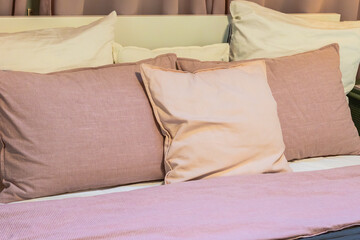 pink and beige pillows on the bed