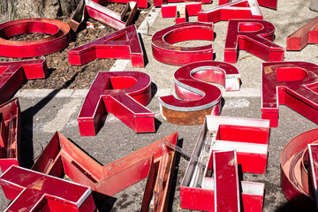 big red and white industrial letters laying on the ground