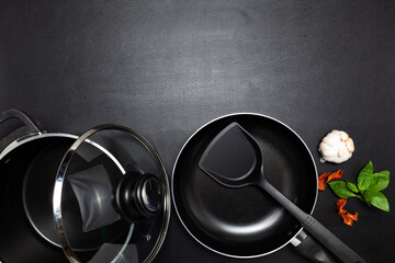 Cooking background Top view frying pan and pot on black leather table background.