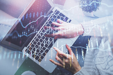 Double exposure of woman hands working on computer and forex chart hologram drawing. Top View. Financial analysis concept.