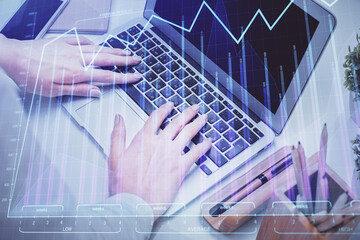 Double exposure of woman hands typing on computer and forex chart hologram drawing. Stock market analysis concept.