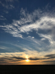 Evening sky with sunset and black field