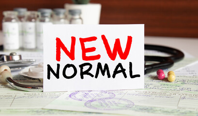 Hand sanitizer and N95 mask against black background with NEW NORMAL text.