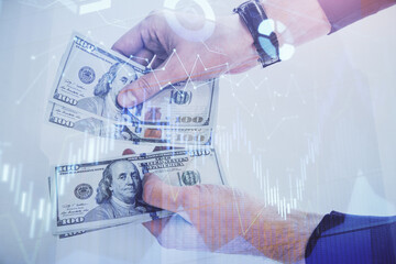 Fototapeta premium Multi exposure of financial graph drawing hologram and USA dollars bills and man hands. Analysis concept.