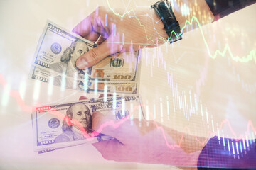 Multi exposure of financial graph drawing hologram and USA dollars bills and man hands. Analysis concept.