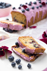 Homemade blueberry cake with pink frosting decorated with berries. Autumn treat for tea time