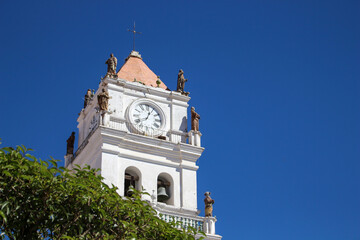 view of historic colonial tower of sucre cathedral with clock and bells