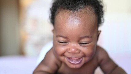 afro american smiling baby lying down - Powered by Adobe