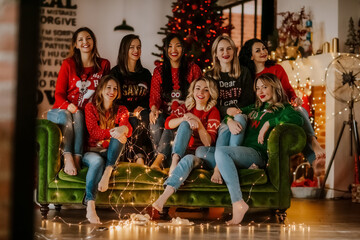 a group of young beautiful women smile on a green sofa