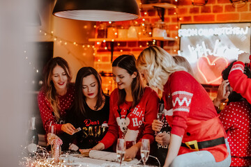 group of young women on Christmas kitchen island making Christmas cookies