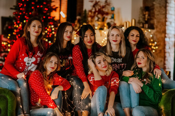 a group of young beautiful women smile on a green sofa