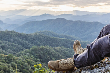 Male Hiker Boots Resting on Mountain Peak with Mountain Lakes in the Background