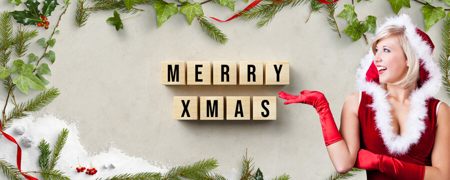 miss santa presenting cubes with message MERRY CHRISTMAS and christmas decoration on paper background