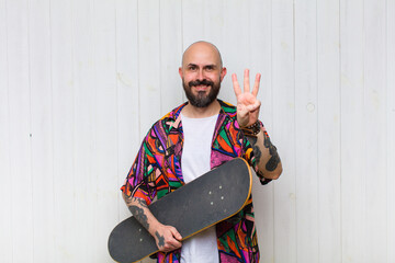bald man smiling and looking friendly, showing number three or third with hand forward, counting...