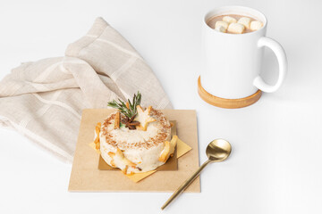 Dessert pastry on wooden plate with golden spoon and chocolate with marshmallows